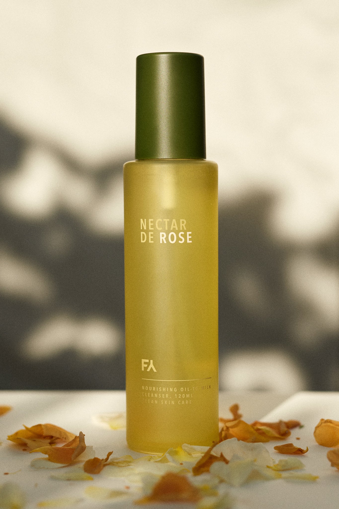 Campaign shot of the Nectar De Rose Nourishing Oil-to-Milk Cleanser with rose petals all around