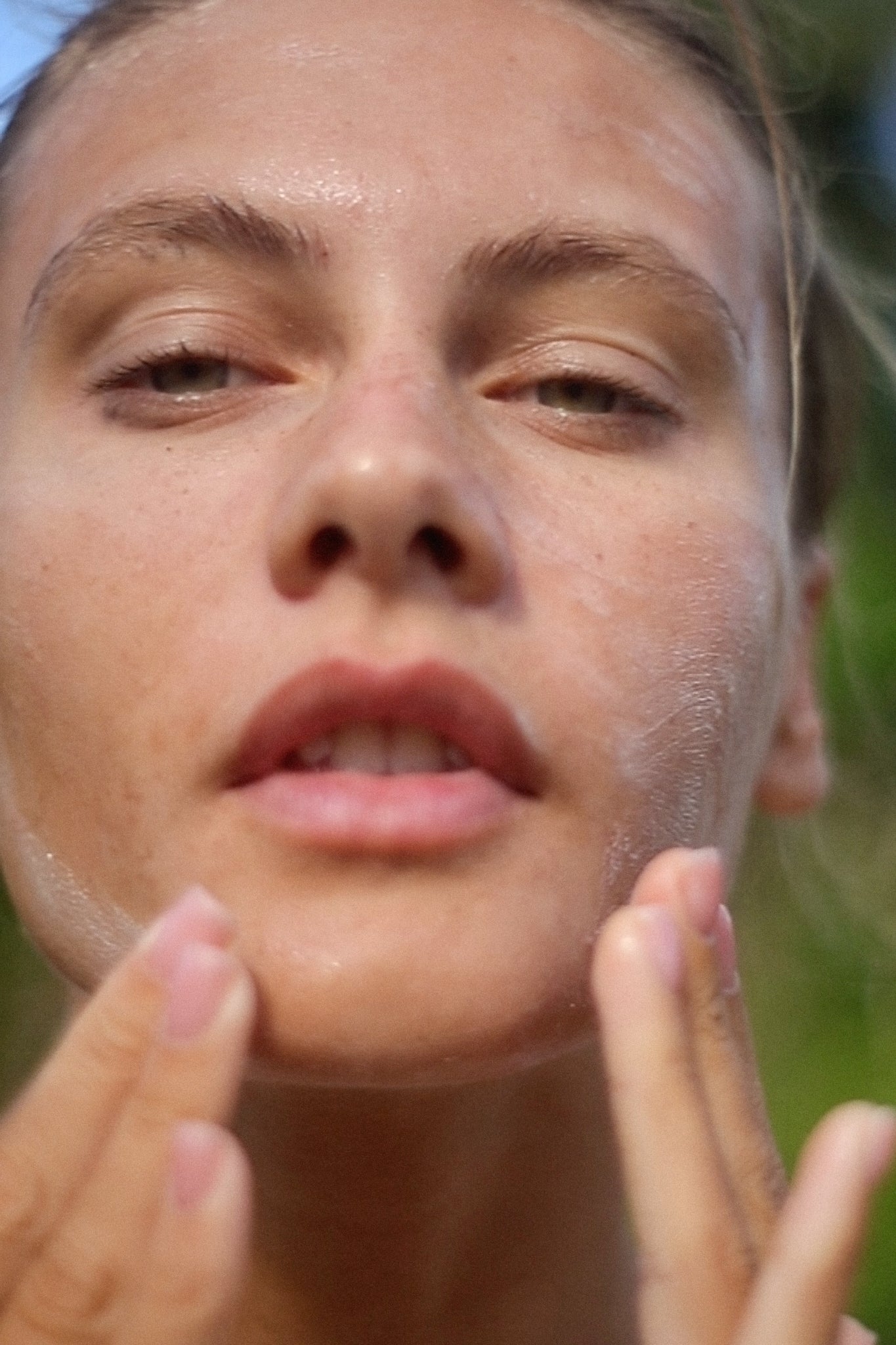 Image of a woman using Fleur de Rose Soothing Cleanser by Fields of Yarrow on her face