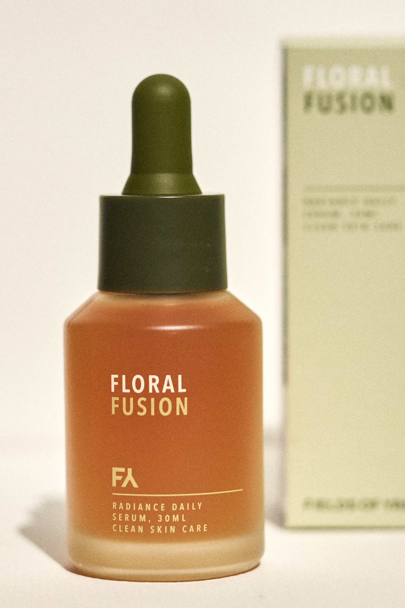 Campaign shot showing the Floral Fusion Radiance Daily Serum by Fields of Yarrow next to its packaging