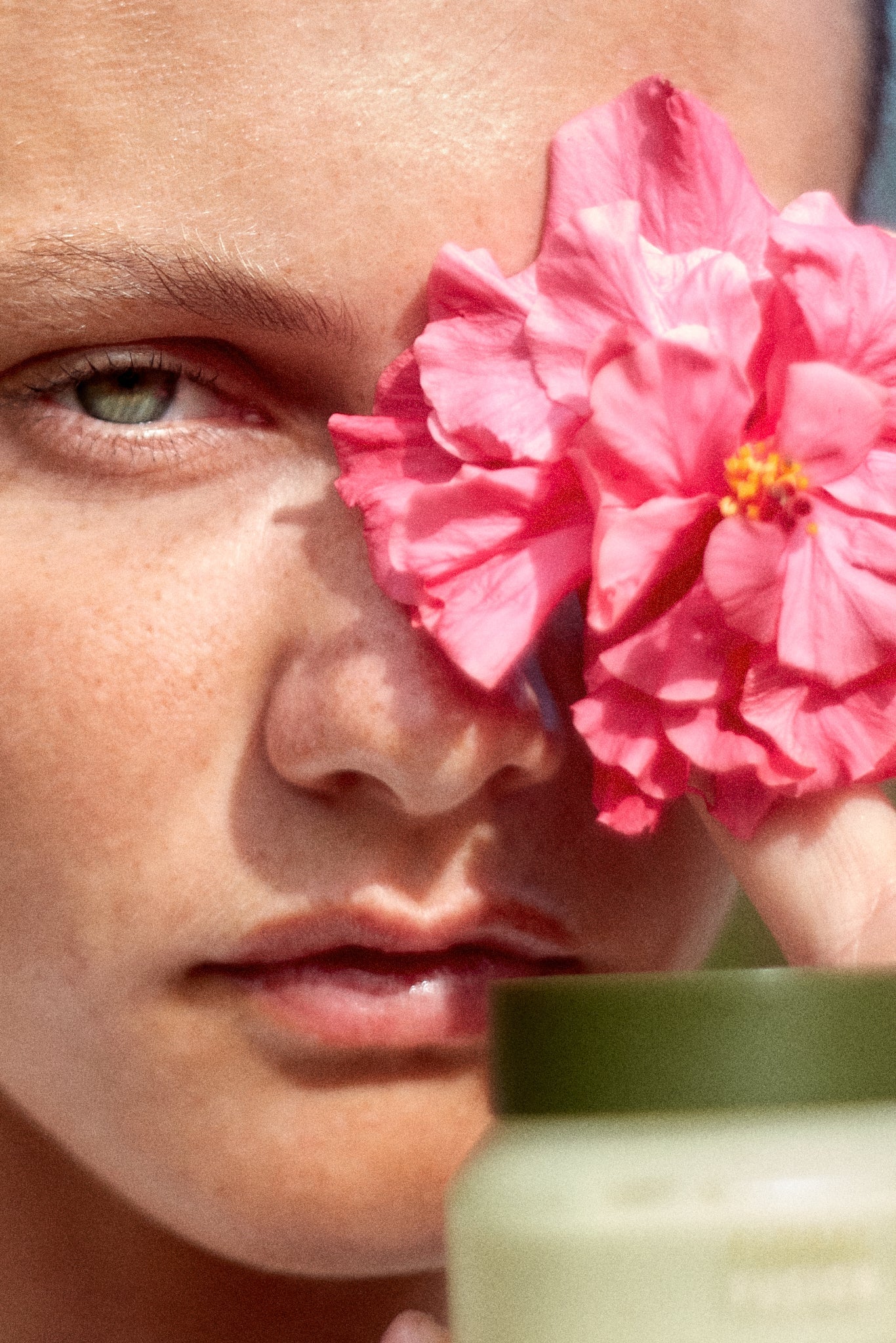 Campaign shot of a model holding a flower and the Floral Fusion Antioxidant Cream by Fields of Yarrow next to her face