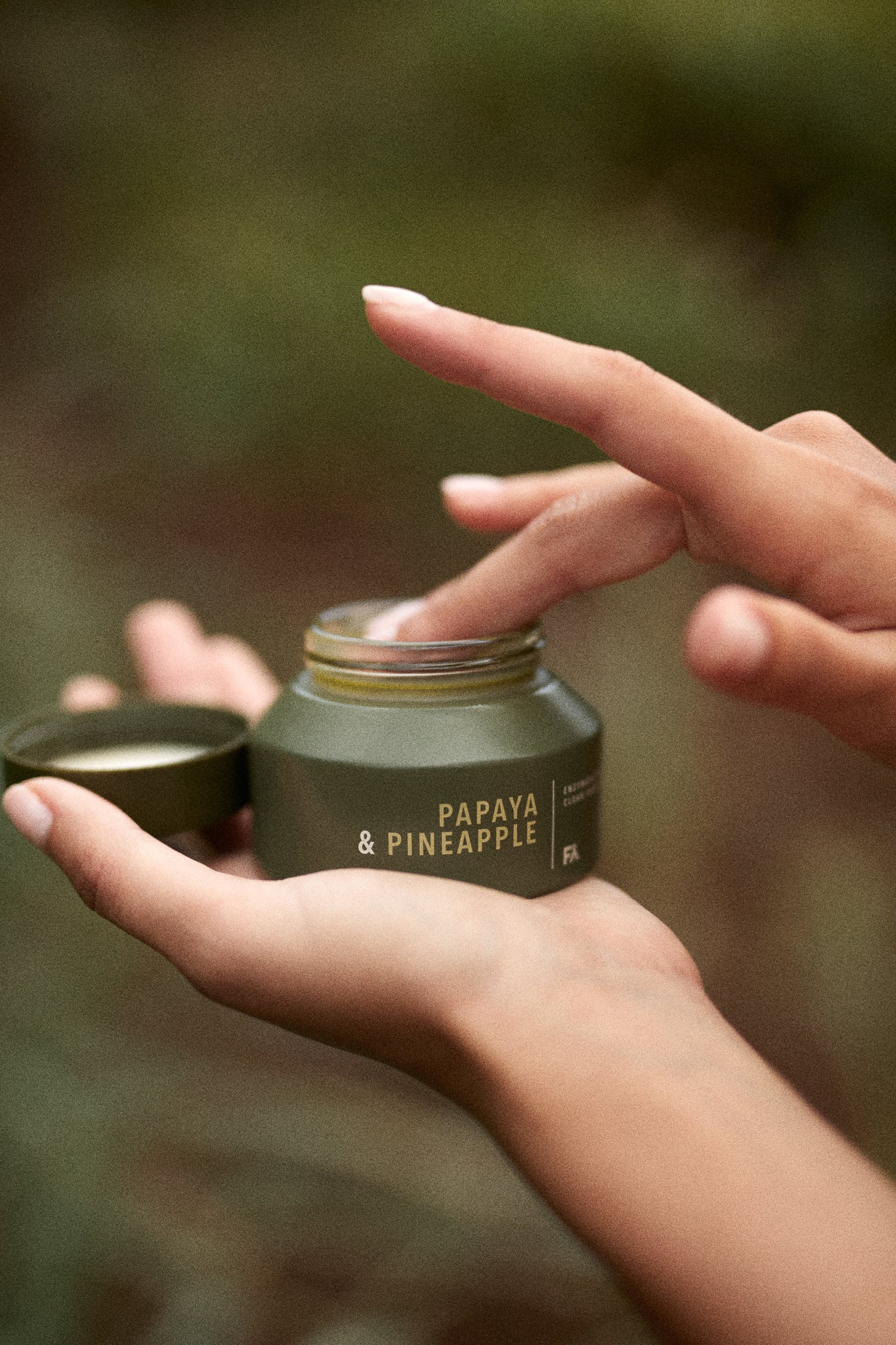 Hands of a girl tippin into the jar of Papaya & Pineapple Enzymatic Cleanser by Fields of Yarrow